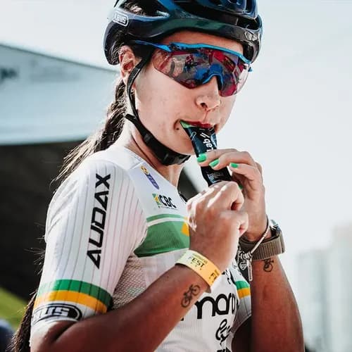 Corredor abrindo um sachê de gel de carboidrato durante a maratona